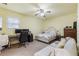 Comfortable bedroom with ceiling fan, a well-lit desk, and a cozy sitting area at 1051 Rock Springs Rd, Lawrenceville, GA 30043