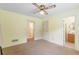 Bedroom with neutral carpet and yellow painted walls featuring ceiling fan at 1051 Rock Springs Rd, Lawrenceville, GA 30043