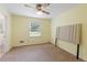 Bedroom with neutral carpet and yellow painted walls featuring a connecting door to bathroom at 1051 Rock Springs Rd, Lawrenceville, GA 30043