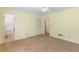 Bright bedroom with neutral carpet, yellow painted walls, and connecting doors to the bathroom at 1051 Rock Springs Rd, Lawrenceville, GA 30043