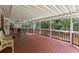 Spacious covered deck with wood floor and railings overlooks a lush green backyard surrounded by mature trees at 1051 Rock Springs Rd, Lawrenceville, GA 30043