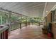 Wide covered deck with wood floor and railings overlooks a lush green backyard surrounded by mature trees at 1051 Rock Springs Rd, Lawrenceville, GA 30043