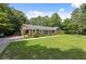 Sprawling brick ranch with a large front yard, mature trees, and a side-entry driveway at 1051 Rock Springs Rd, Lawrenceville, GA 30043