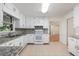 Bright kitchen with white cabinets, tile backsplash, granite counters and tile floors at 1051 Rock Springs Rd, Lawrenceville, GA 30043