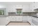 Bright kitchen with white cabinets, tile backsplash, granite counters and tile floors at 1051 Rock Springs Rd, Lawrenceville, GA 30043