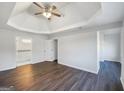 Spacious bedroom featuring tray ceilings, modern ceiling fan, and hardwood floors at 225 Woodfield Ct, Mcdonough, GA 30253