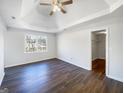 Spacious bedroom featuring tray ceilings, modern ceiling fan, and hardwood floors at 225 Woodfield Ct, Mcdonough, GA 30253