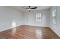 Spacious living room featuring wood floors and a view to the yard from two large windows for natural light at 3159 Nursery Se Rd, Smyrna, GA 30082