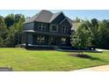 Charming two-story home boasts a well-maintained lawn, mature trees, and inviting curb appeal at 5484 Two Hills Dr # 32, Fairburn, GA 30213