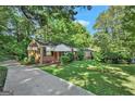 Quaint brick home featuring a walkway, green lawn, and a driveway leading to the residence at 2576 Godfrey Nw Dr, Atlanta, GA 30318