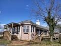 Brick home exterior showing a wooden deck, a screened porch, and a covered area with trellis at 0 Hawkins Academy Rd, Social Circle, GA 30025