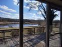 A view from a screened porch through the screen showing a lake and trees in the background at 0 Hawkins Academy Rd, Social Circle, GA 30025
