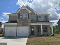 Charming two-story home with gray brick, covered entry and a two-car garage at 1613 Fuma Leaf Way # 273, Mcdonough, GA 30253