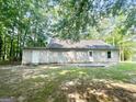 The backyard shows a gray sided house with two white doors and a small concrete patio at 110 Peridot Pl, South Fulton, GA 30349