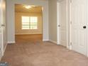 Hallway view featuring neutral-toned walls, plush carpeting, and entryways leading into other rooms at 207 Millwheel Dr, Villa Rica, GA 30180