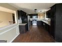 Kitchen with black cabinetry, stainless steel appliances, and wood-look flooring at 3393 Madison Farm Way, Snellville, GA 30039