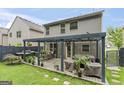 Home backyard features a wooden deck with pergola, grill, outdoor dining, and covered furniture at 5768 Grande River Rd, Atlanta, GA 30349