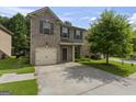 Home exterior elevation features a combination of brick and siding, attached garage, and lawn at 5768 Grande River Rd, Atlanta, GA 30349