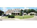 Beautiful two-story home featuring a brick and stone facade, lush landscaping, and a well-manicured front lawn at 6510 Bentley Ridge Dr, Cumming, GA 30040