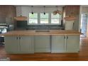 Updated kitchen with butcher block island, green cabinets, and granite countertops at 2381 County Line Sw Rd, Atlanta, GA 30331