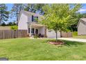 Inviting home with a well-kept lawn, mature tree, and a cozy front porch at 1018 Nandina Ct, Villa Rica, GA 30180