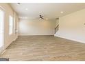 Spacious living room with wood-look flooring, large windows, and a staircase, creating an inviting atmosphere at 189 Orwell Dr # 47, Social Circle, GA 30025