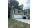 Two-story house with green siding, white garage doors, and a spacious driveway at 2961 Forelock Sw Pl, Marietta, GA 30064