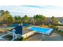Aerial view of community pool and tennis courts surrounded by mature trees at 1678 Lacebark Elm Way, Lawrenceville, GA 30045
