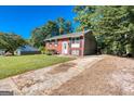 Charming red brick house with manicured lawn, concrete driveway, and lush green trees at 6671 Pelica Ct, Riverdale, GA 30274