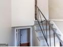 Stairwell with dark railing and grey painted stairs leading to a landing with doorways at 6671 Pelica Ct, Riverdale, GA 30274