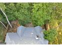 Aerial view of the house highlighting the roof, back deck, and surrounding mature trees for privacy at 3192 Creek W Trce, Powder Springs, GA 30127