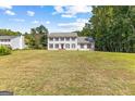 Traditional two-story home with black shutters, surrounded by lush trees, and a sprawling front lawn at 330 N Fayette Dr, Fayetteville, GA 30214