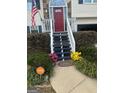 Front entry with stairs, red door, and landscaping at 3870 Michaels Creek Ct, Loganville, GA 30052