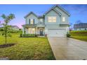 Two-story light blue house with a two-car garage and front yard at 1168 Bodega Loop, Locust Grove, GA 30248