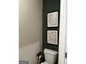Stylish half bath featuring a modern toilet and decorative artwork at 253 Ivey Ter # 48, Temple, GA 30179