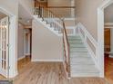 Grand foyer featuring staircase, hardwood floors, and white trim with neutral paint at 2560 Almont Way, Roswell, GA 30076