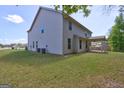A spacious backyard showing the back of the home and a covered patio at 161 Jodi Pl, Locust Grove, GA 30248