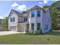Two-story home featuring a three-car garage and a neatly manicured front yard at 161 Jodi Pl, Locust Grove, GA 30248