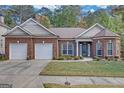 Charming brick home featuring a two-car garage, manicured lawn, and inviting entrance with well-maintained landscaping at 4424 Bellwood Cir, Atlanta, GA 30349