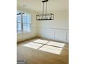 Bright dining room with hardwood floors, wainscoting, and a modern light fixture at 140 Dockside Dr # 381, Fayetteville, GA 30215