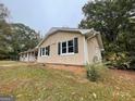 A side view of the home with large windows and a well-maintained brick foundation at 2177 E Chester Cir, Conyers, GA 30013