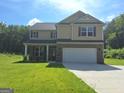 Two-story home with brick and siding, a two-car garage, and a well-manicured lawn on a sunny day at 200 Parker Dr, Mcdonough, GA 30253
