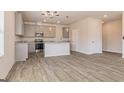 Bright kitchen with stainless steel appliances, a center island, and modern light fixtures over wood grain floors at 359 Orwell Dr # 53, Social Circle, GA 30025