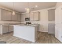 Kitchen with gray cabinets, granite countertops, a center island, and stainless steel appliances offers contemporary style at 359 Orwell Dr # 53, Social Circle, GA 30025