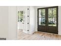 Bright entryway with dark brown double doors and hardwood floors at 2611 Charlesgate Ave, Decatur, GA 30030