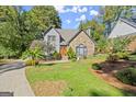 Stone and gray siding house with a manicured lawn at 7445 Talbot Colony, Sandy Springs, GA 30328