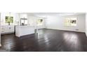 Spacious open-concept living room featuring dark hardwood floors and a bright, renovated kitchen at 504 Milligan Dr, Stone Mountain, GA 30083