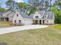 Beautiful white farmhouse exterior with a spacious three car garage and a long driveway at 241 Ben Horton Dr, Mcdonough, GA 30253
