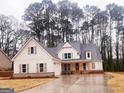 Beautiful white farmhouse exterior with brick accents, a long driveway and inviting front porch at 241 Ben Horton Dr, Mcdonough, GA 30253