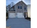 Charming two-story gray home with white trim, two-car garage, and modern black door at 209 Weldon Rd # 43, Mcdonough, GA 30253